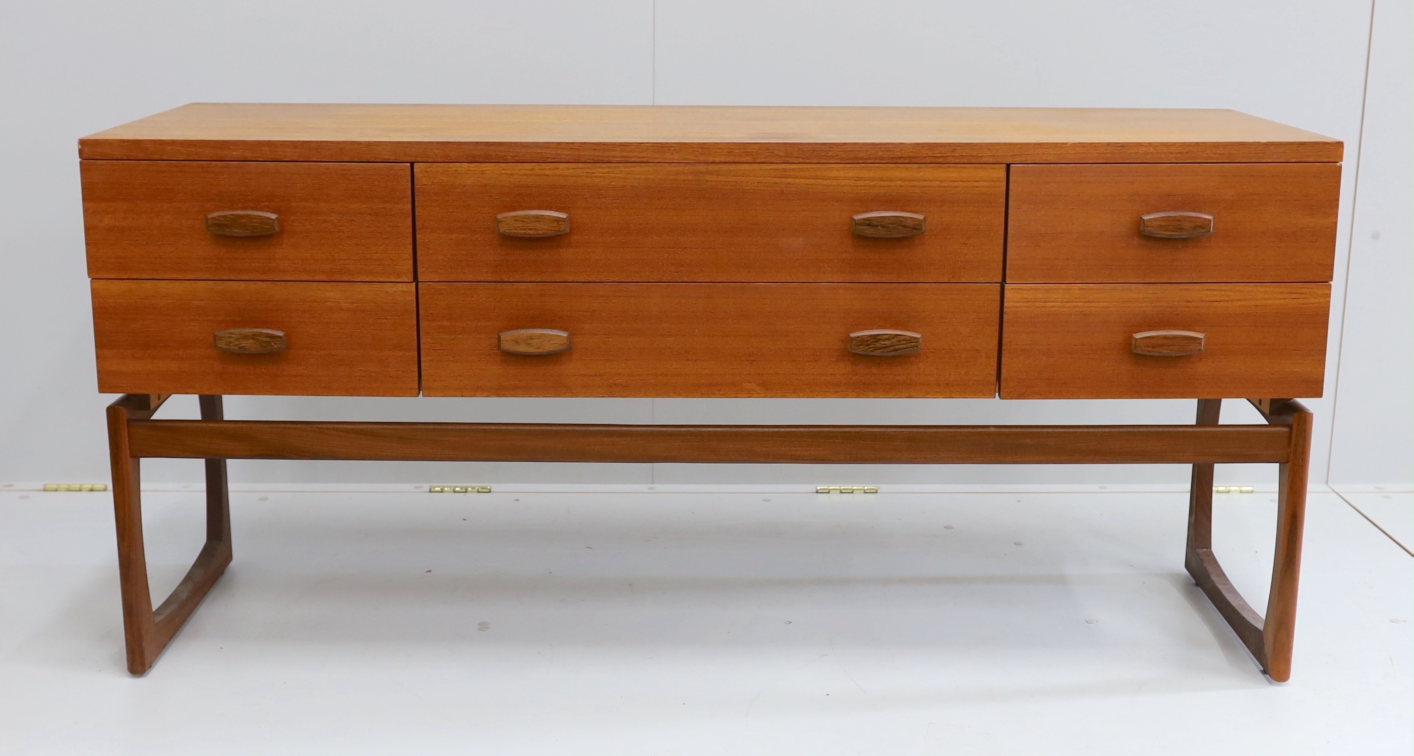 Ib Kofod Larsen for G Plan, a teak six drawer dressing table, length 152cm, depth 46cm, height 71cm (mirror back present but in need of repair)